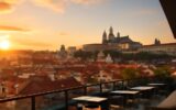 Rooftop bar v Praze s panoramatickým výhledem na střechy a Pražský hrad při západu slunce