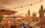 Letní terasa s výhledem na pražské střechy za zlaté hodiny