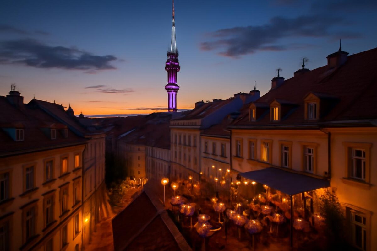 Žižkov v létě po setmění – střechy, televizní věž a hospůdky