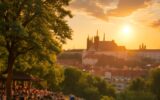 Lidé na svahu v Riegrových sadech při západu slunce s výhledem na Pražský hrad