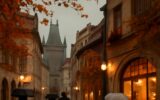 Pražská ulice za deště s odlesky na dlažbě a osvětlenými kavárnami