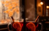 Dvě sklenice svařeného vína s pomerančem a skořicí v útulné pražské kavárně